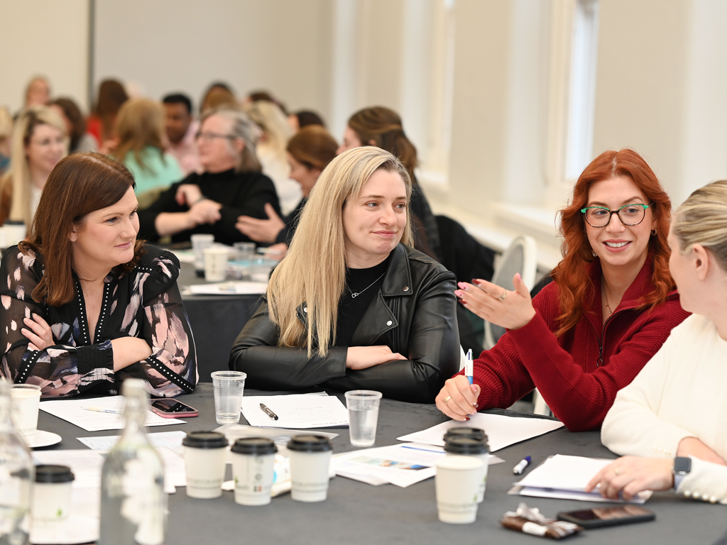 INMO members attending a PDC course sitting at table chatting and interacting